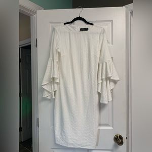 White knee length cocktail dress with sleeves.